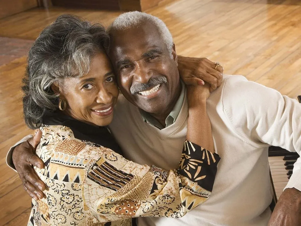 Senior couple laughing together after full-arch restoration