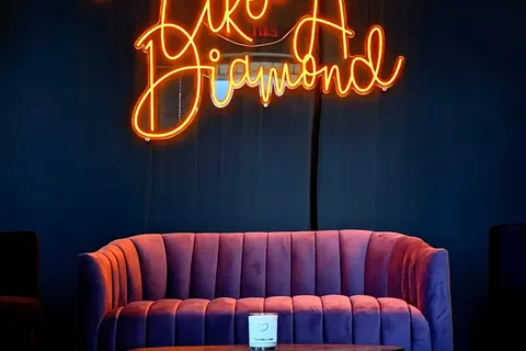 The Smile Bar lounge — neon sign above the velvet sofa