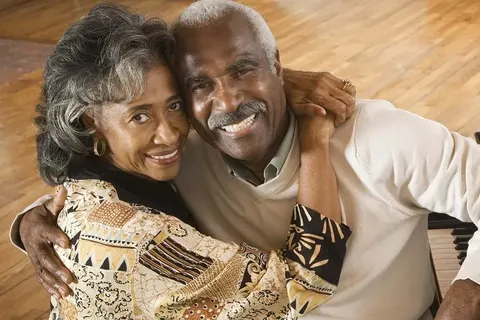 Senior couple laughing together after full-arch restoration